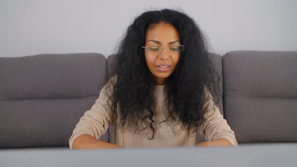 Friendly and smiling online teacher woman typing message on laptop computer