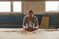 Craftsman working with chisel while cutting wooden plank in carpentry workshop and looks camera - PhotoDune Item for Sale