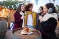 Happy smiling friends eating chocolate with churros together on street outdoors. Festival in winter. - PhotoDune Item for Sale
