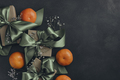 Gift boxes with olive green ribbons tied in a bow, tangerines, black background, top view. - PhotoDune Item for Sale