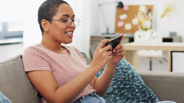 Happy Woman Playing Game on Smartphone at Home