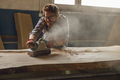Professional male carpenter using electric sander for wood. Manufacture of wood products  - PhotoDune Item for Sale