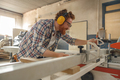 Male carpenter sawing a board with a circular saw in a carpentry workshop. High quality - PhotoDune Item for Sale