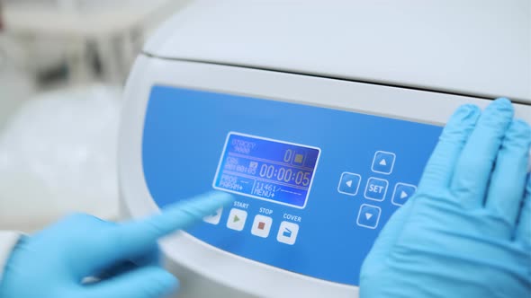 Close Up Scientist Stops the Centrifuge and Opens It Using the Button