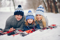 Little girl with parents sitting on a blanket in a winter park - PhotoDune Item for Sale