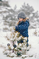 Little girl in a blue hat playing in a winter forest - PhotoDune Item for Sale