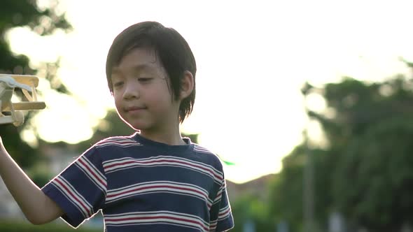 Cute Asian Child Playing Wooden Airplane In The Park Outdoors Slow Motion 