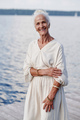 Happy senior woman posing near the lake - PhotoDune Item for Sale
