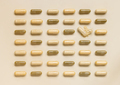 Mix of medical capsules in lines on light beige top view. Dietary supplements - PhotoDune Item for Sale