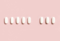 Mix of medical pills with one empty place in a line on light pink top view. Dietary supplements - PhotoDune Item for Sale