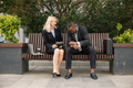 Black businessman sitting on a bench and talk with caucasian woman in front of modern office - PhotoDune Item for Sale