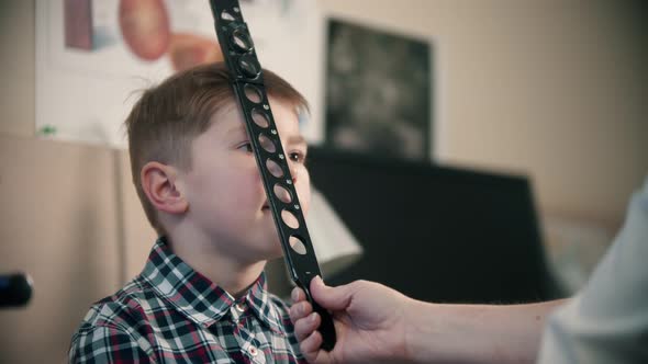 A Little Boy Having a Treatment in Eye Clinic - a Woman Doctor Checking an Eye Visibility of a