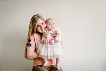 Greeting for a mother with the newborn baby girl who holding the flower. Women's Day. Mother's Day
