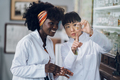 Japanese pharmacist is holding a bottle of powder and showing it to her african american colleague - PhotoDune Item for Sale