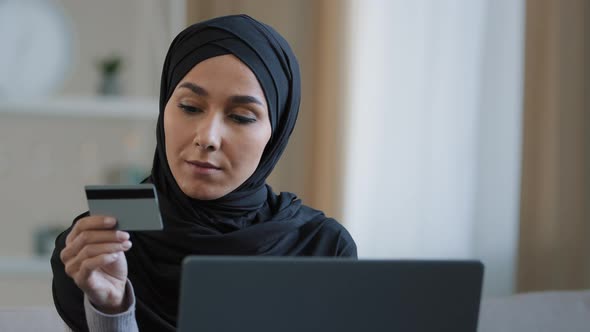 Attractive Girl in Hijab Holding Credit Card Pay Online Order Use Banking Application on Laptop