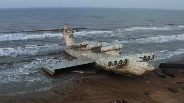 A giant abandoned aircraft crashed on the coast. Hybrid amphibian crashed plane