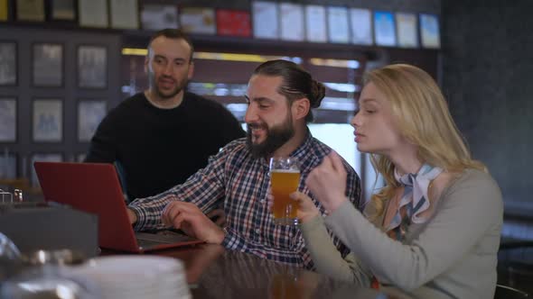 Positive Smiling Man Closing Laptop Clinking Toasting with Friends Drinking Beer Watching Match on