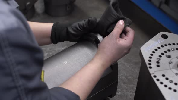 A Worker Puts Gloves on His Hands to Work with Manufactured Detail Checks for Quality and Compliance