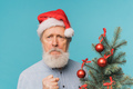 Angry sad Santa scares kids, man wears santa hat show aggressive emotions - negative and bad mood - PhotoDune Item for Sale