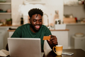 Portrait of a cheerful man using a credit card and a laptop for e-banking - PhotoDune Item for Sale