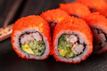 California sushi roll with crab, avocado, cucumber and tobiko caviar served on black board close-up - PhotoDune Item for Sale