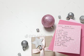 Gift boxes, balls and paper with list on white background, space for text