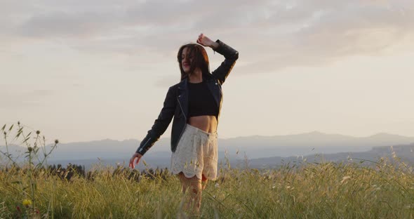 Young woman enjoying life and freedom at the land at sunset.