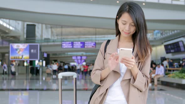 Travel woman working on her mobile phone in the airport