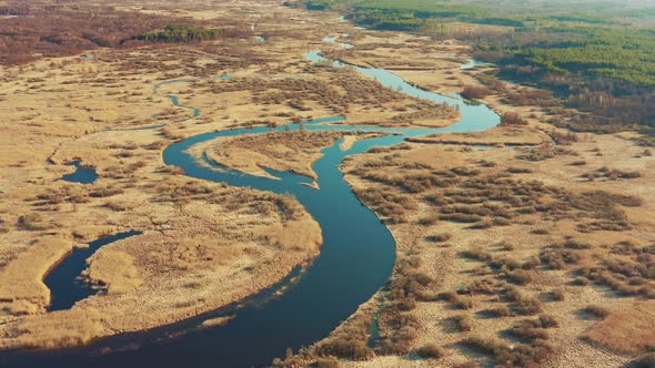 Aerial View Of Forest Woods And Partly Frozen River Landscape In Sunny Late Autunn Day