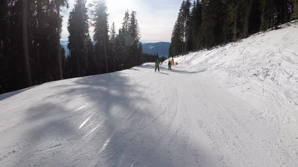 Slide Down on Ski Slope at Ski Resort. POV View on Skiers and Snowboarders