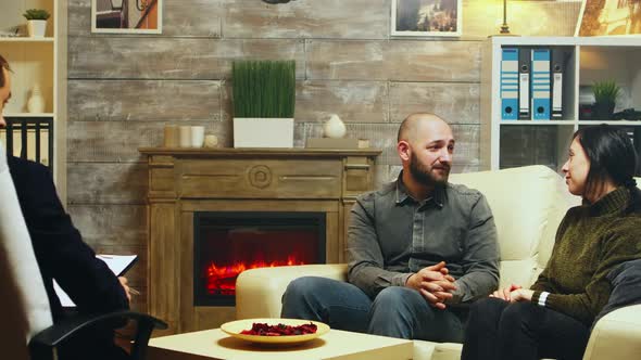 Young Couple Hug Each Other Sitting on Couch at Therapy