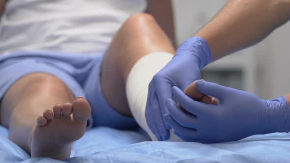 Doctor Examining Patients Leg in Elastic Bandage, Trauma Rehabilitation Medicine