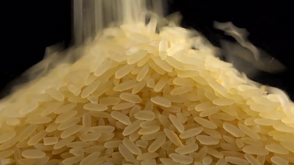 Pouring rice on a black background.