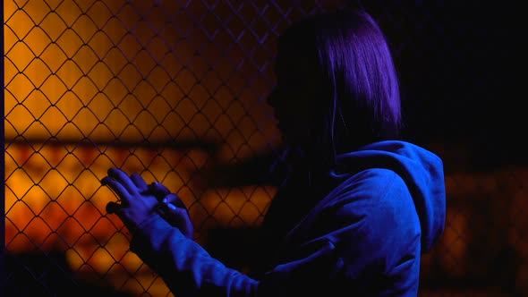 Sad Teenage Girl Hiding Near Wire Fence, Family Relationship Crisis, Awkward Age