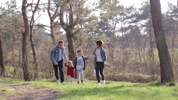 Happy family concept. Young mother and father kissing their daughter in the park.