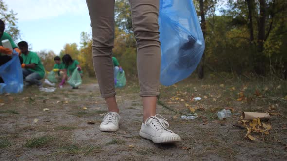 Legs of Woman Volunteer Picking Up Plastic Trash