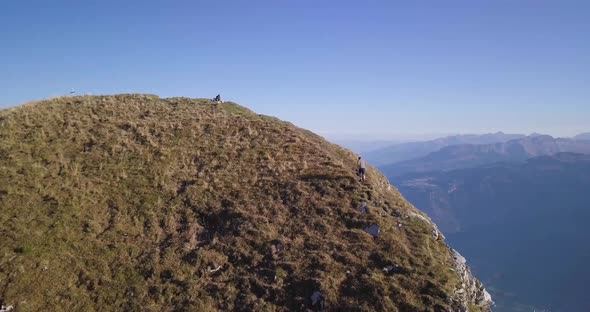 Panoramic view of a huge mountain ridge in Switzerland while fall. A young hiker runs up and stumble