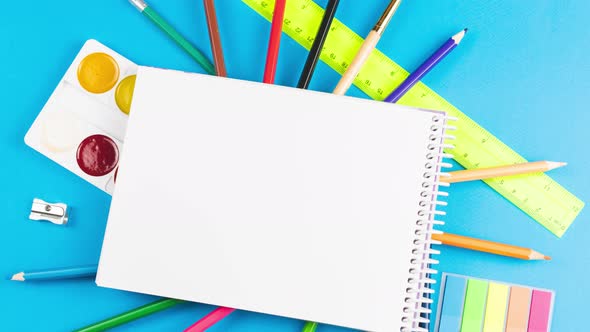 School Supplies for the First of September are on a Pastel Blue Background