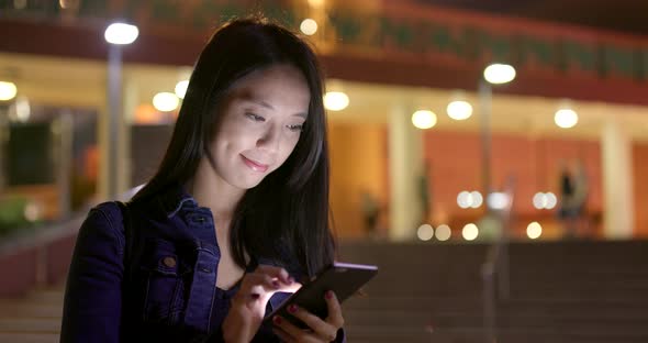 Woman use of mobile phone on earphone at night