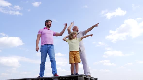 Boy Kid with Father and Grandfather Hold Paper Planes Pointing Fingers Skyhigh Aim