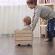 Older boy riding his baby brother in wooden toy cart - VideoHive Item for Sale