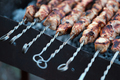 Lots of metal skewers with meat cooking on coals. Cooking pork barbecue. - PhotoDune Item for Sale