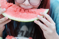 Girl eating a slice of ripe red watermelon, close-up. - PhotoDune Item for Sale