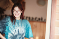 Happy red-haired teenage girl with glasses stands in the doorway. Wide smile, braces on teeth. - PhotoDune Item for Sale