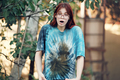 Shocked red-haired teenage girl with glasses shows a dirty T-shirt. - PhotoDune Item for Sale