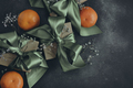 Gift boxes with olive green ribbons tied in a bow, tangerines, black background, top view.  - PhotoDune Item for Sale