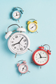 Collection of alarm clocks of different colors show different times.  - PhotoDune Item for Sale