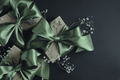 Gift boxes with olive green ribbons tied in a bow. Black background, top view.  - PhotoDune Item for Sale