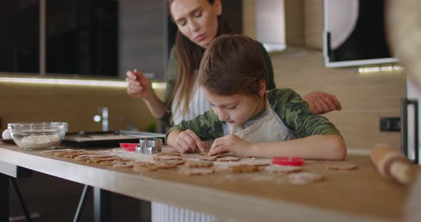 Young Mother and Son Cooking Cookies Together in the Kitchen