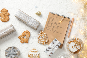 Cookies, gift boxes and notepad with list on white background, top view